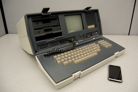 An Osborne Executive portable computer, from 1982, and an iPhone, released 2007. The Executive weighs 100 times as much, has nearly 500 times the volume, cost 10 times as much, and has a 100th the processing power of the iPhone.